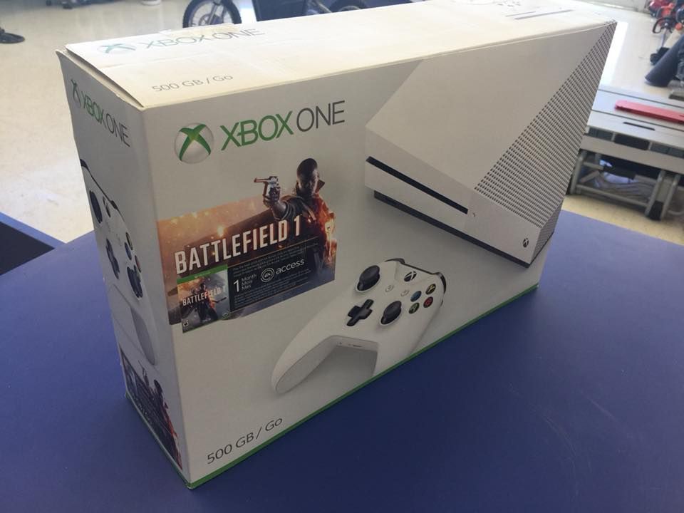 Xbox One console box set with Battlefield 1 game and white controller on blue table.