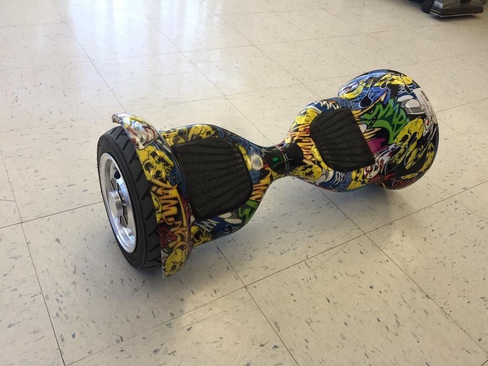 Hoverboard with colorful graffiti pattern on a tiled floor.