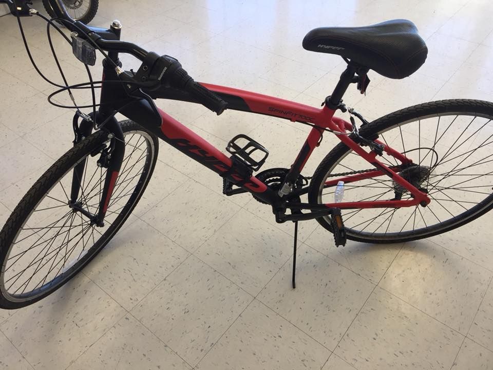 Red and black hybrid bicycle on a tiled floor.