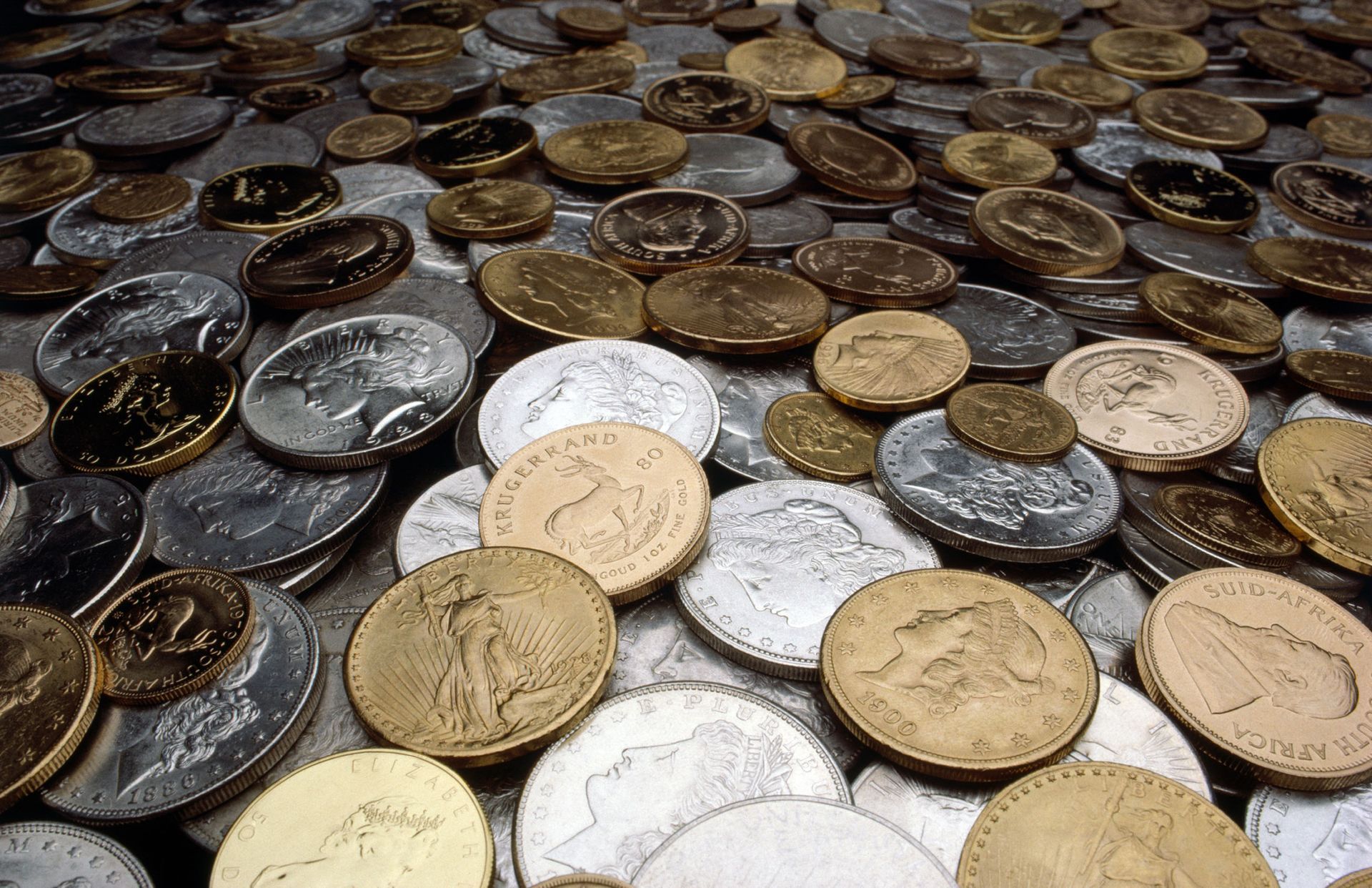 Pile of gold and silver coins scattered on a surface.
