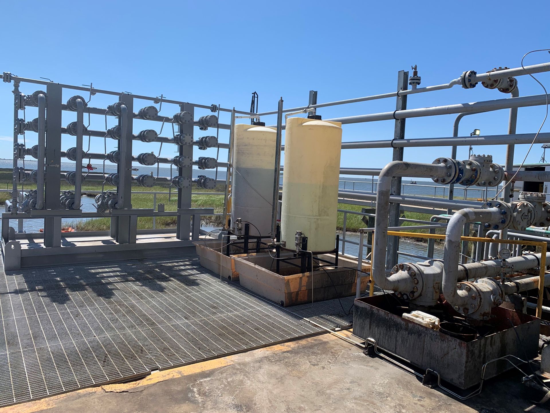A fenced in area with a lot of pipes and tanks