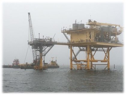 A large oil rig is in the middle of the ocean.