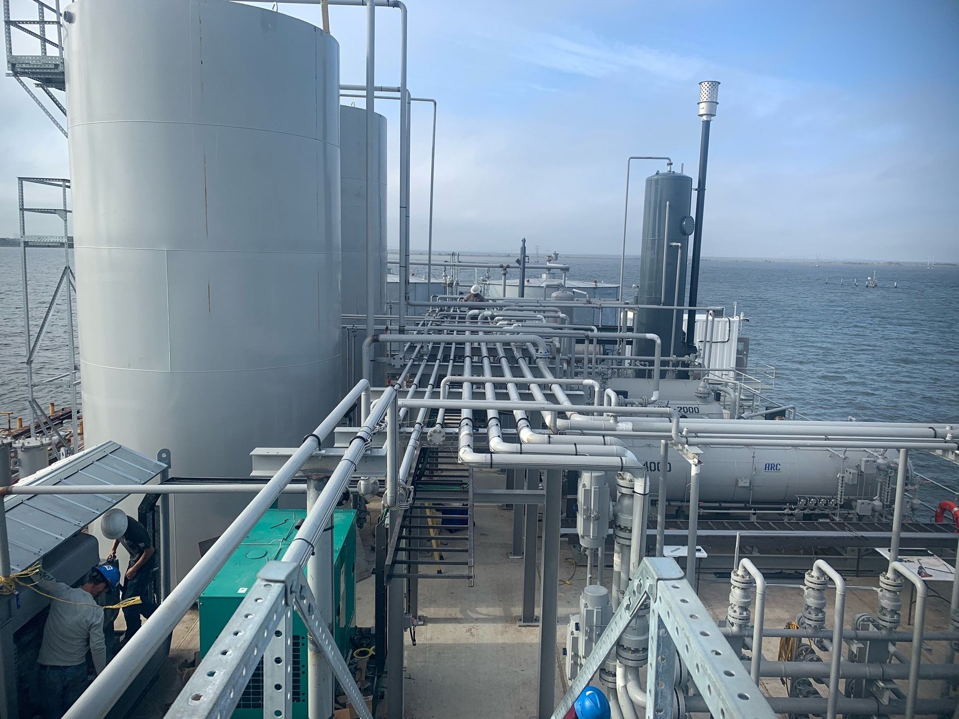 A large ship with a lot of pipes and tanks on the deck.