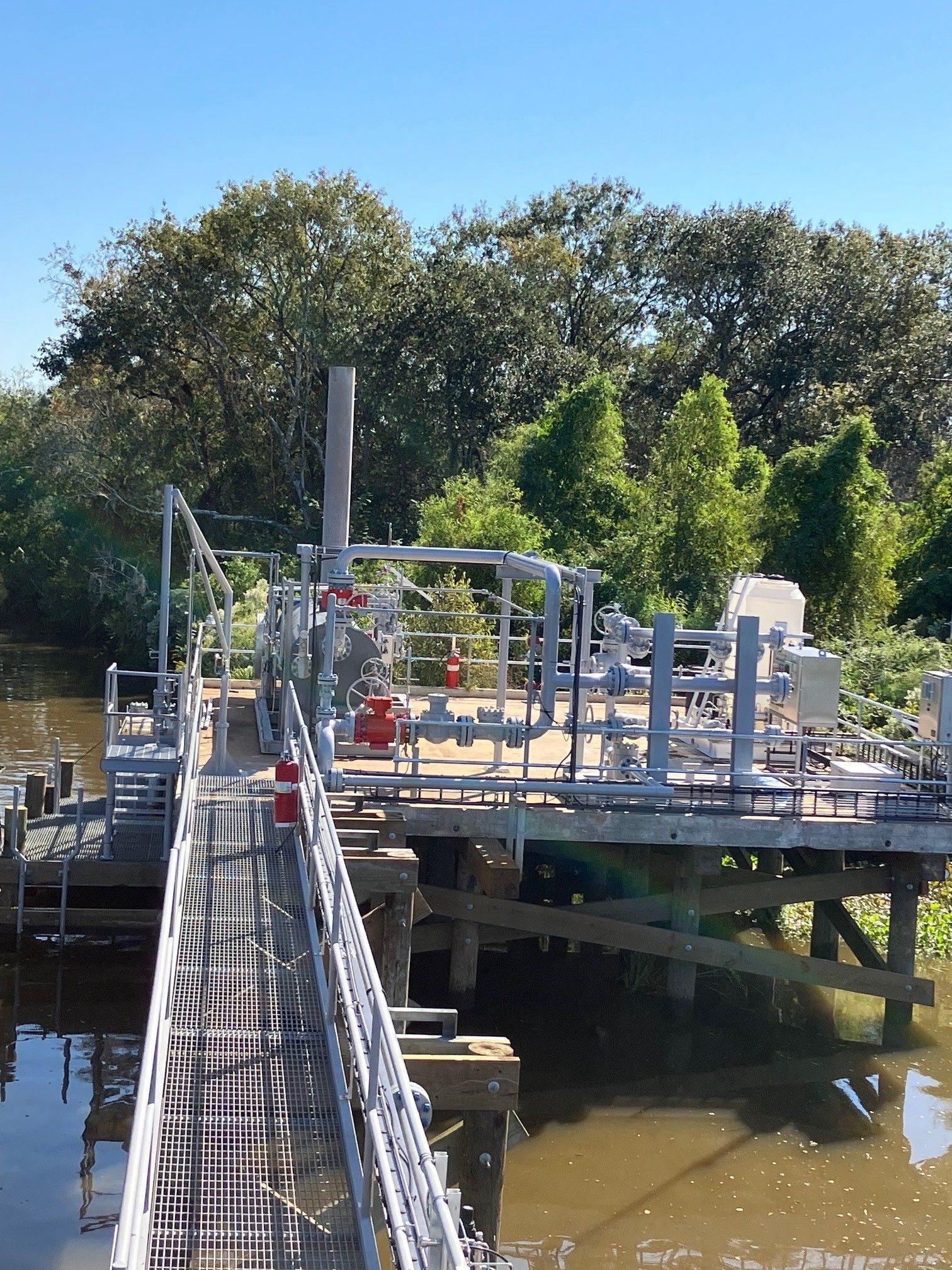 A bridge over a body of water with trees in the background