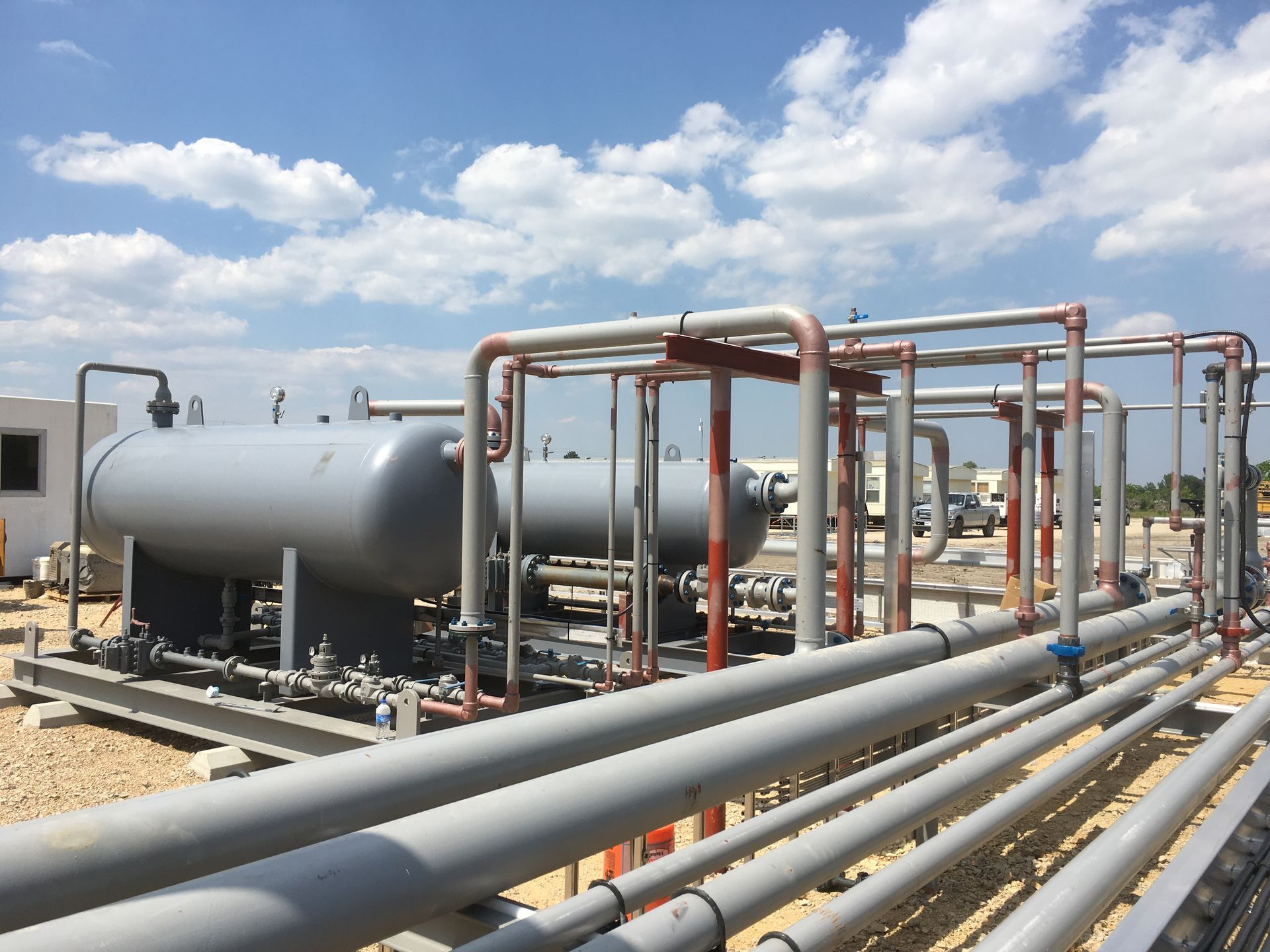 A bunch of pipes are lined up in a field