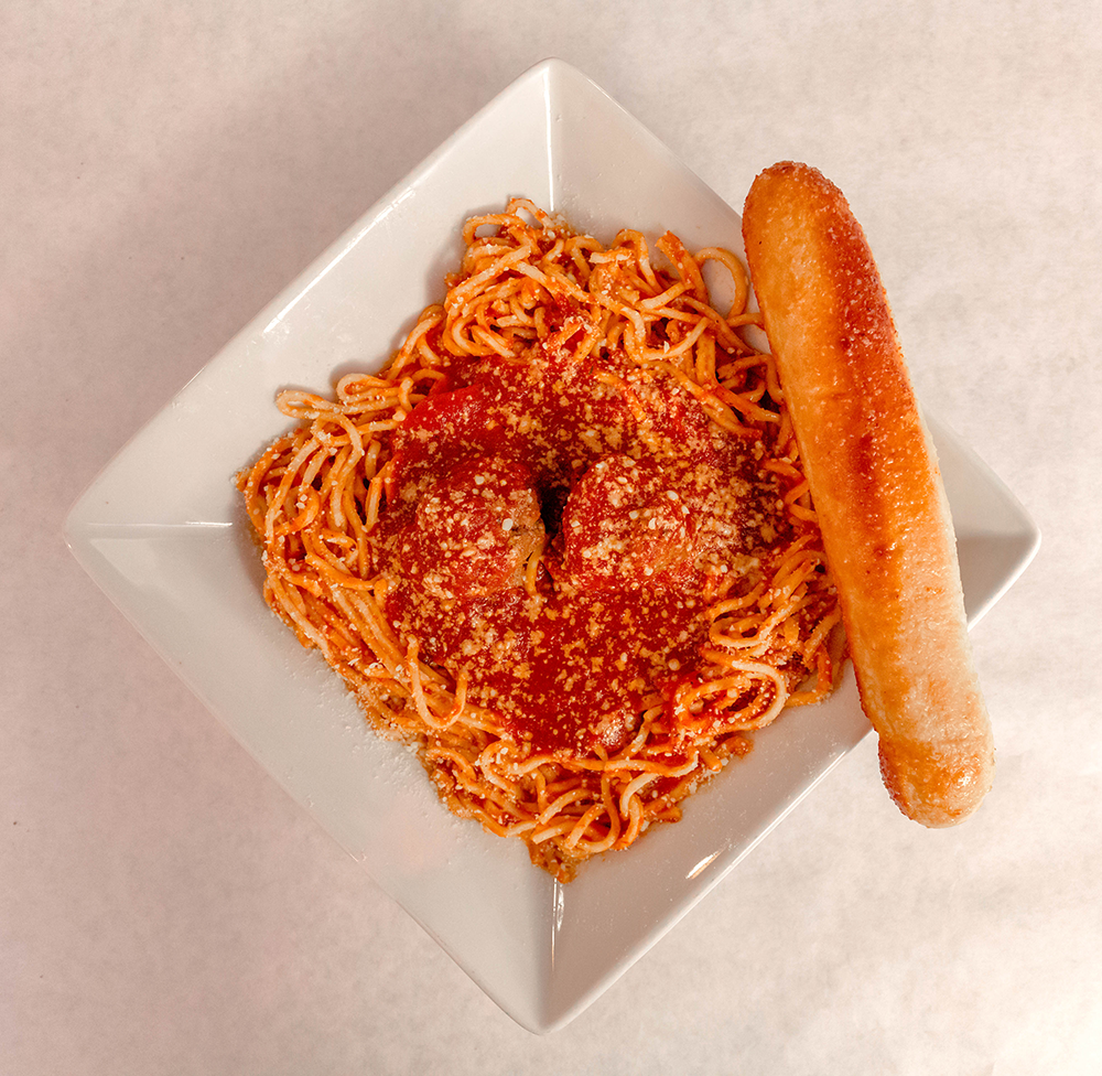 Spaghetti with red sauce and grated cheese on a white plate, with a breadstick on the side