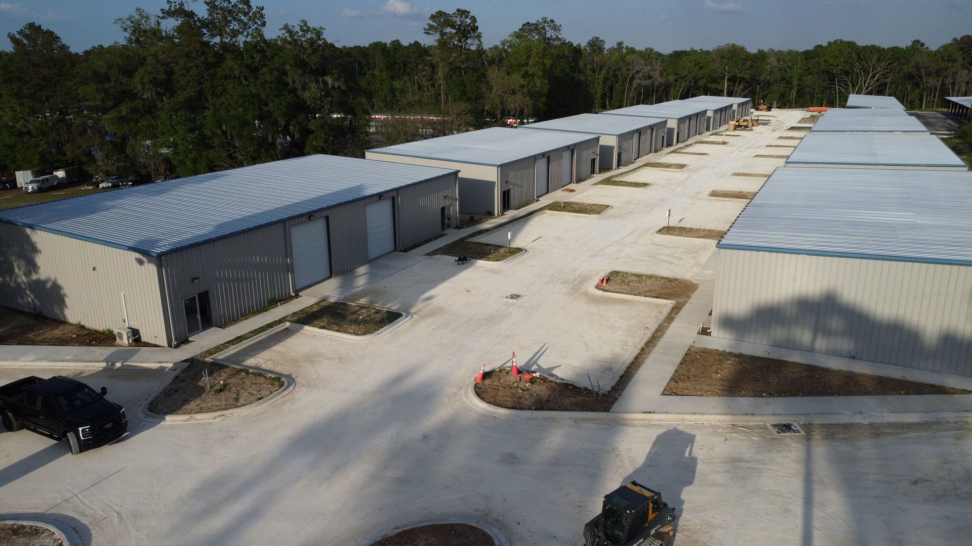 Aerial view of a large industrial complex with long gray-roofed buildings and paved roads between them