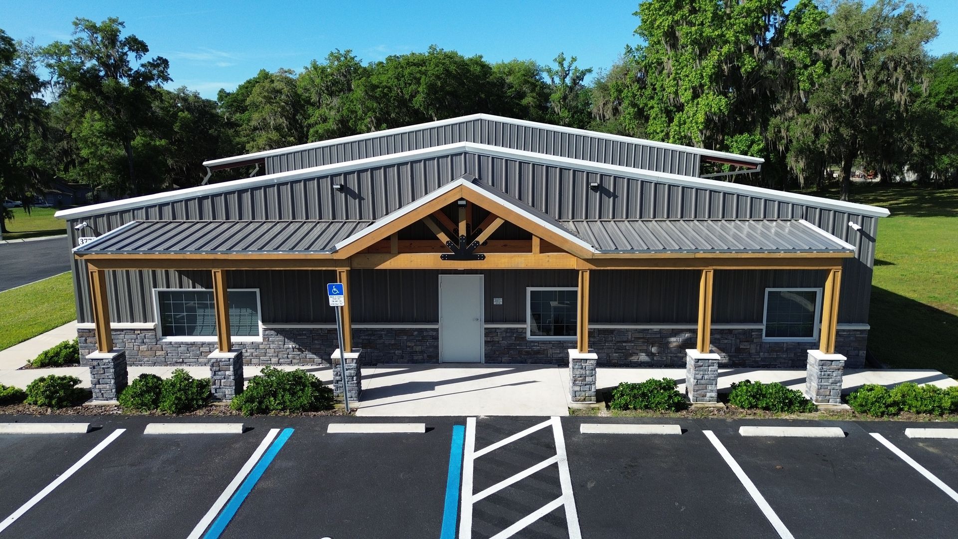 Small yellow building with gray roof and accessible parking spaces in front