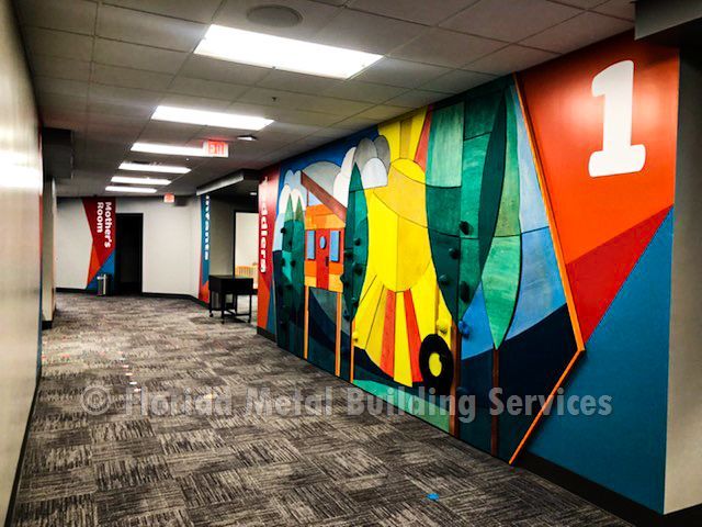 Hallway with colorful geometric mural wall and large orange “1” on the right