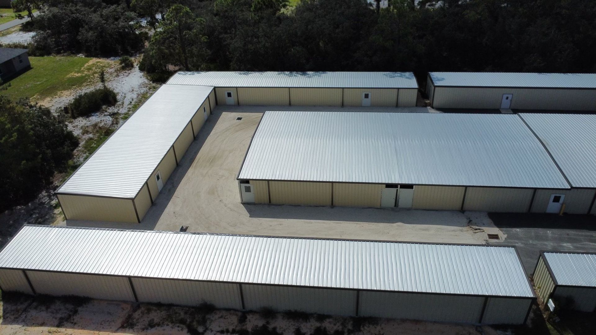 Aerial view of white-roofed modular buildings arranged around a central courtyard.