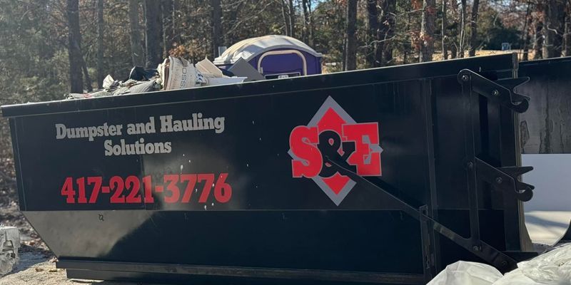 Black dumpster labeled