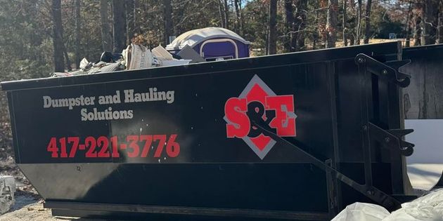 Black dumpster labeled 