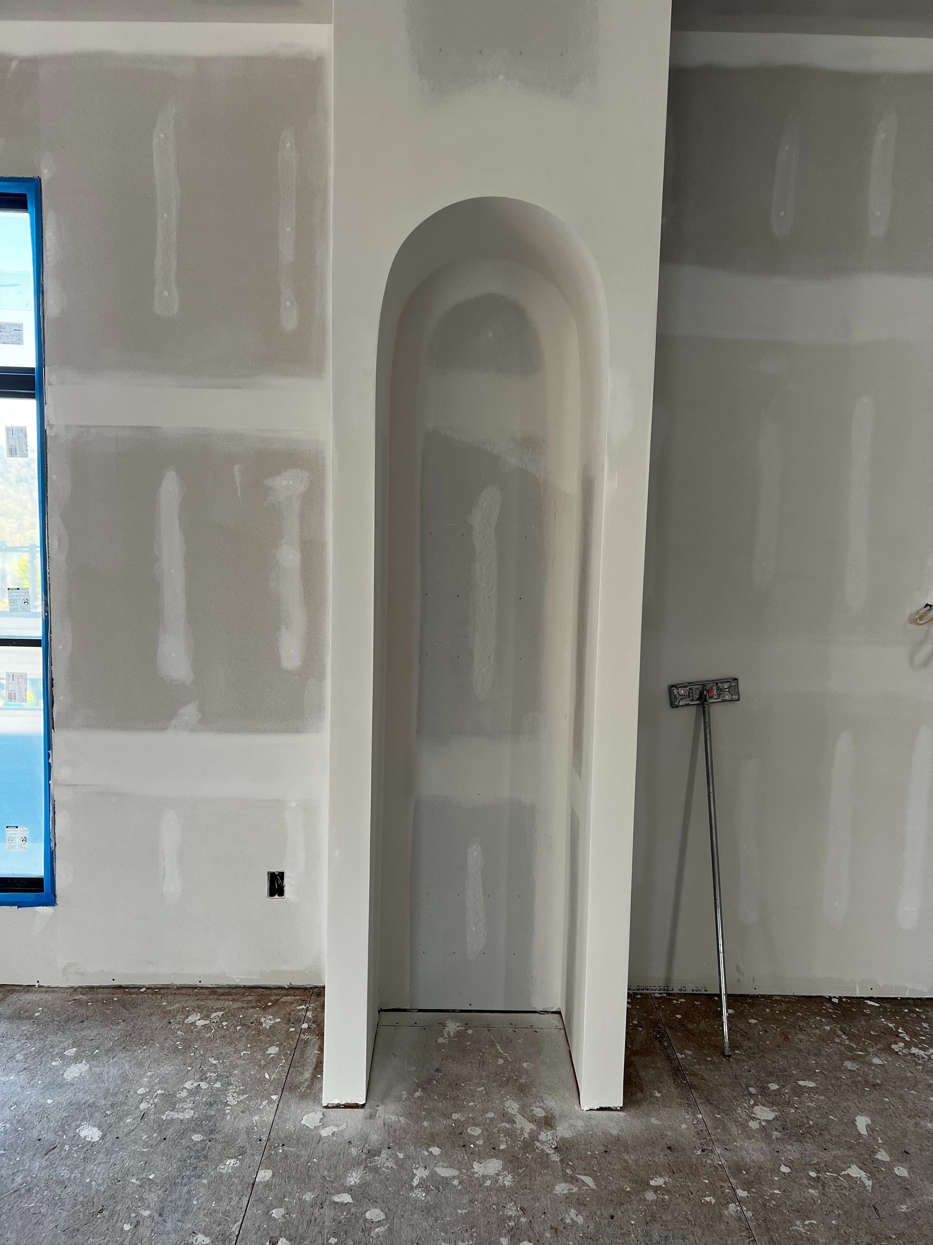 Interior wall under construction with an arched niche.