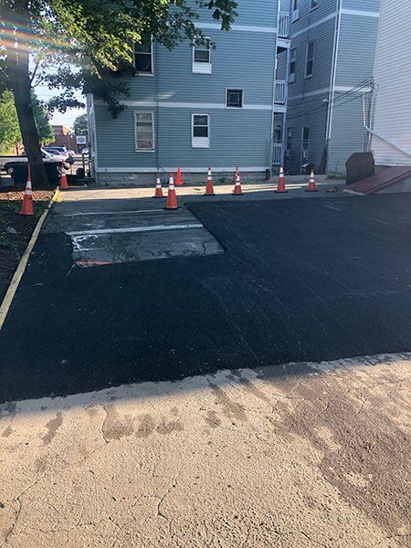 A parking lot with cones and a building in the background.