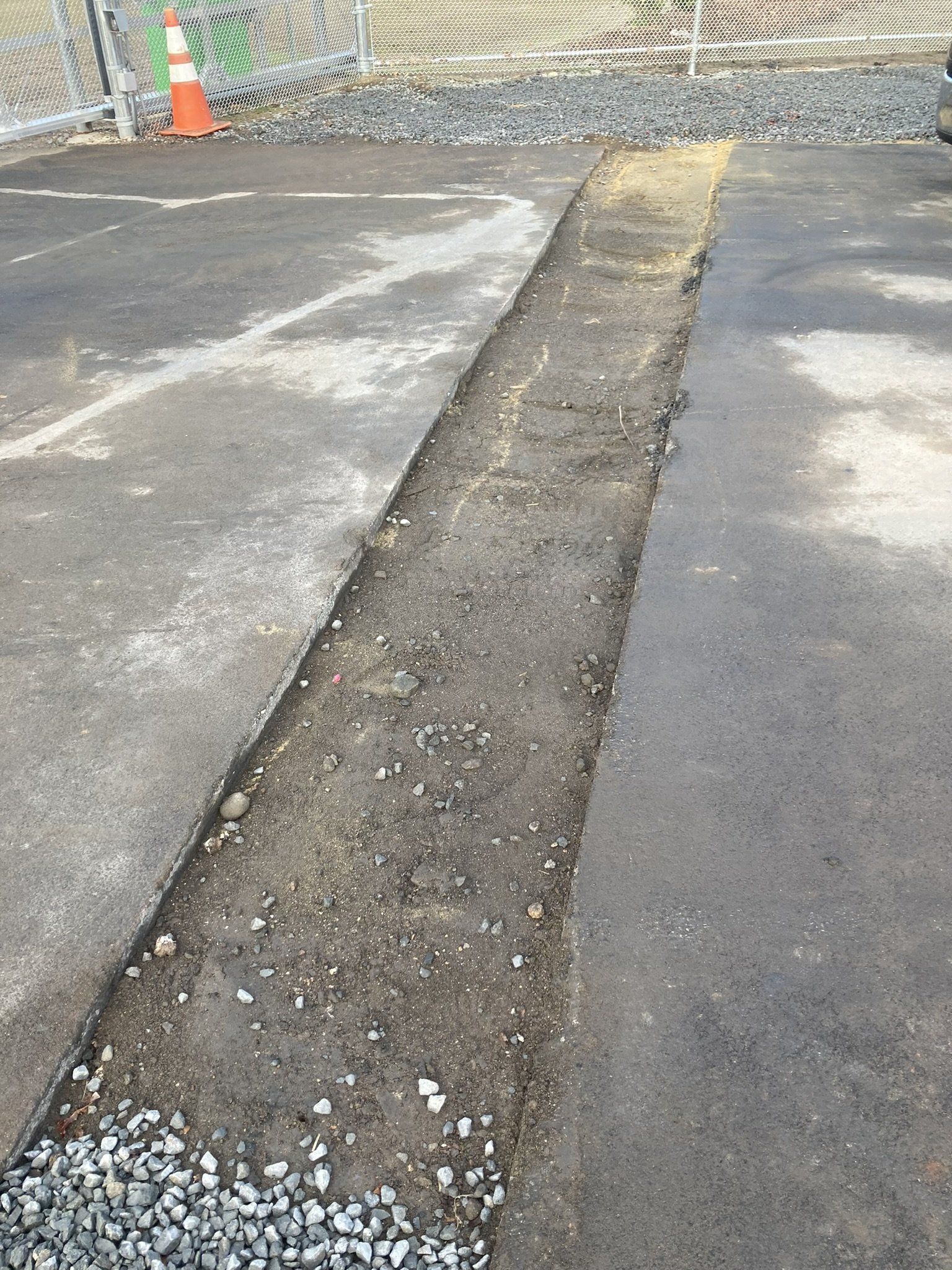 A concrete curb is being built in a parking lot.
