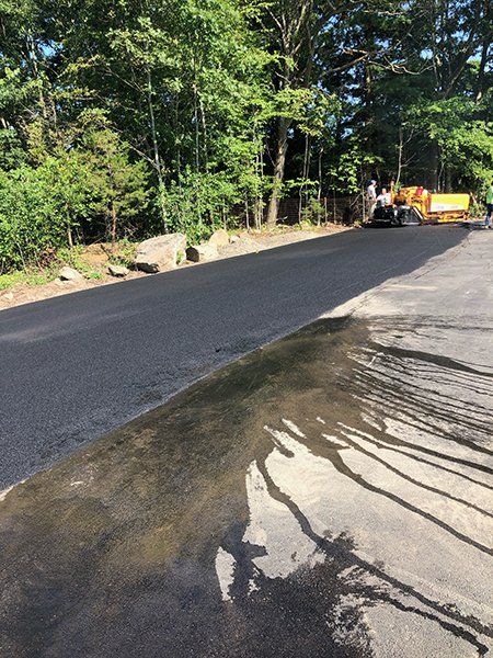A large puddle of water is on the side of a road.
