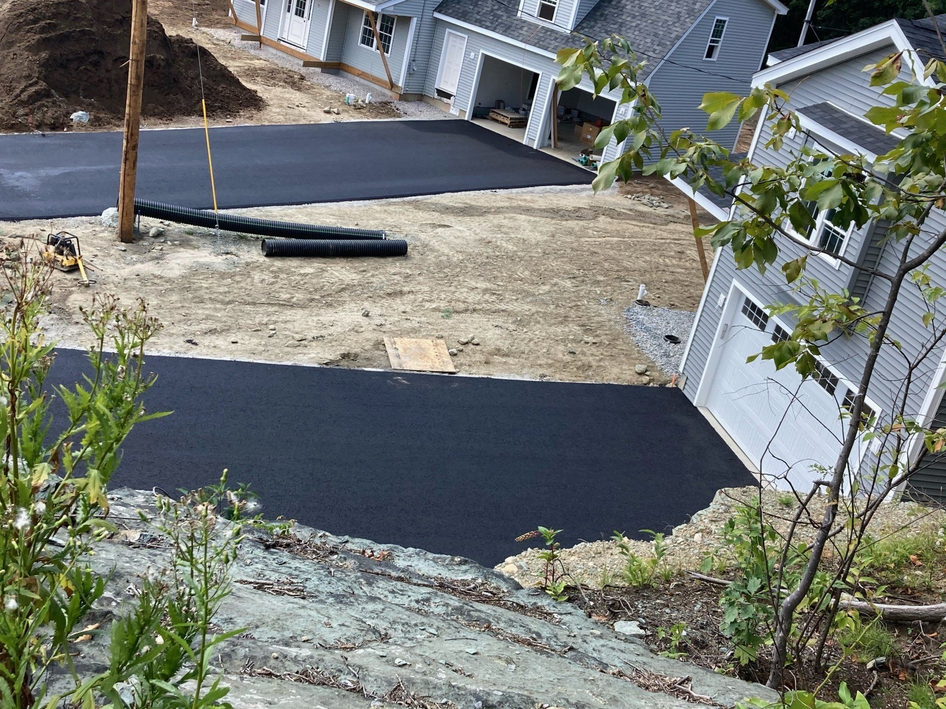 A house is being built on a hill next to a road.