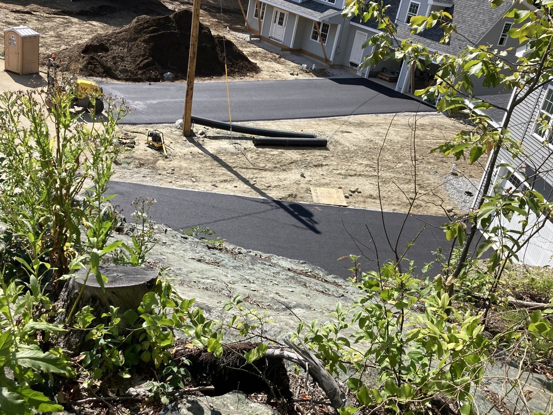 A view of a construction site with a house in the background.