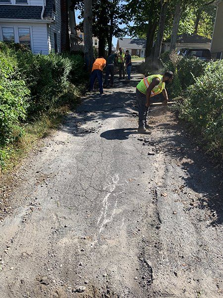 A group of people are working on a dirt road.