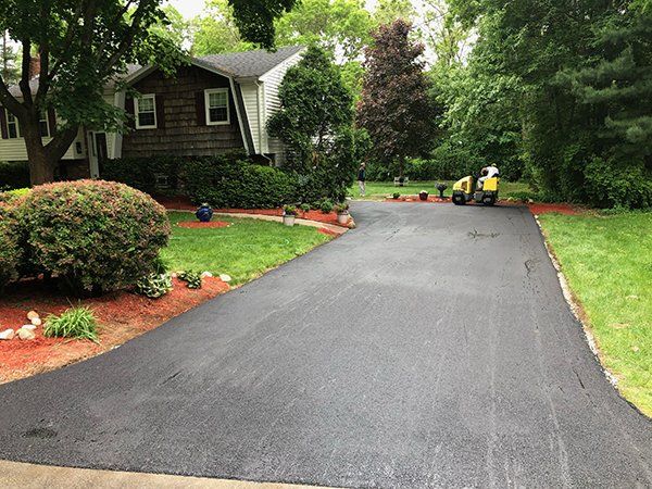 A driveway is being paved in front of a house.