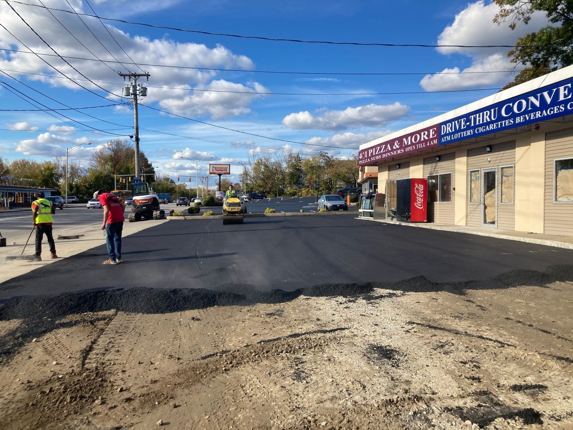 A group of people are working on a road in front of a building.