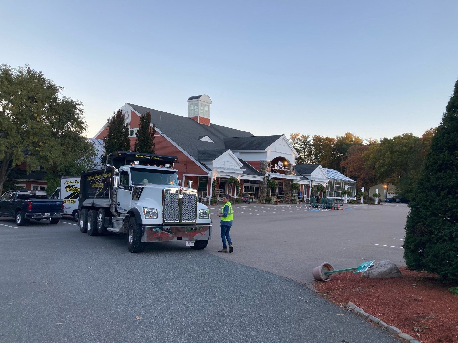 A large white truck is parked in front of a large building.