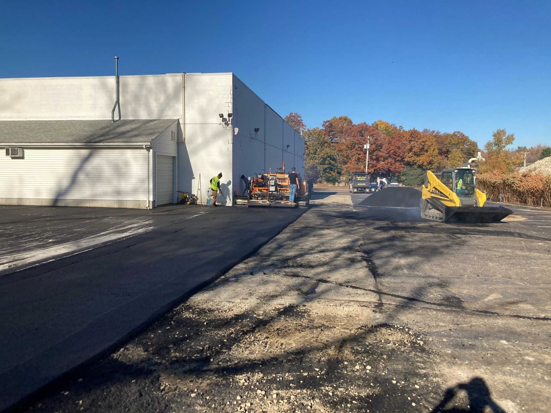 A group of people are working on a road in front of a building.