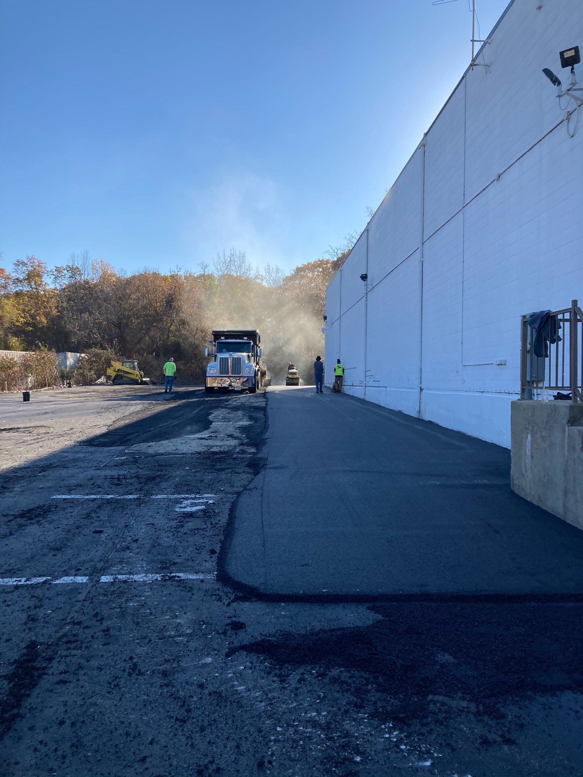 A truck is driving down a road next to a building.