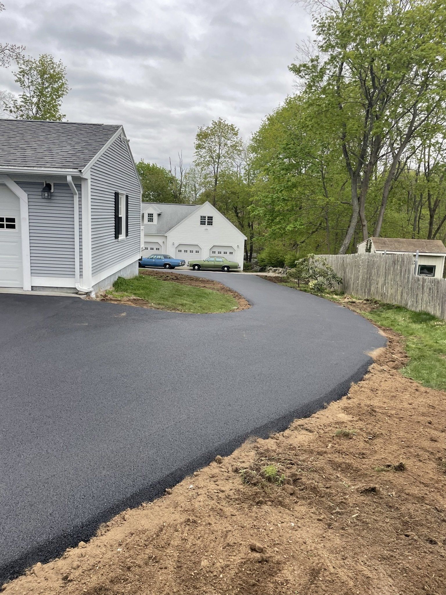 A driveway leading to a house with a car parked in front of it.