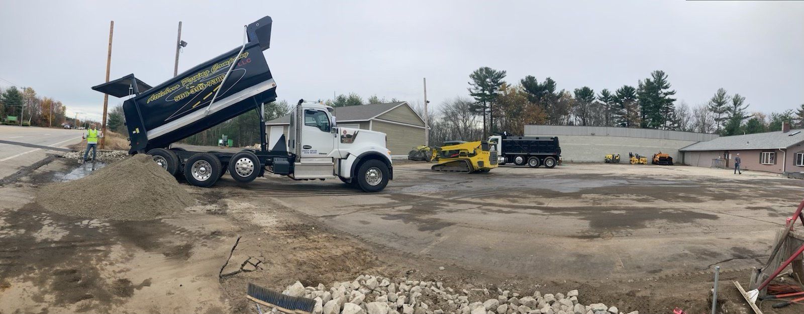 A dump truck is dumping dirt on a construction site.
