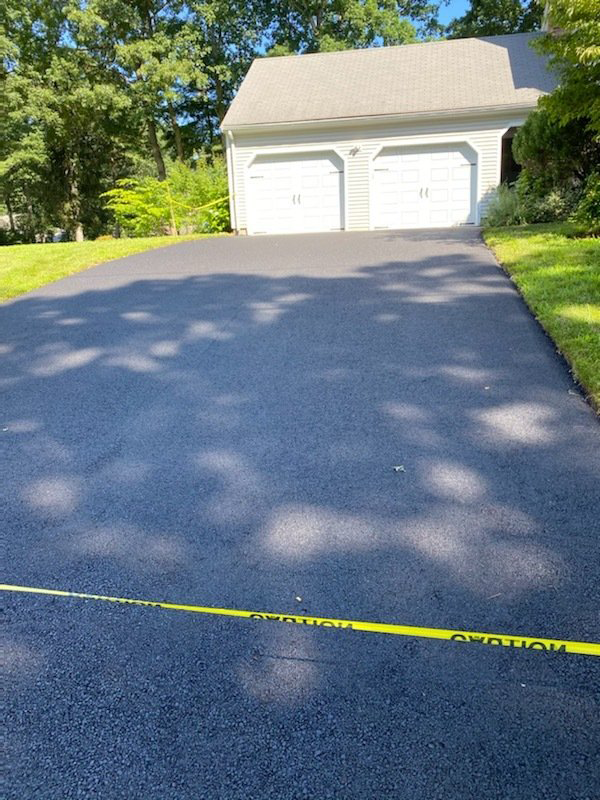 A driveway leading to a house with two garage doors