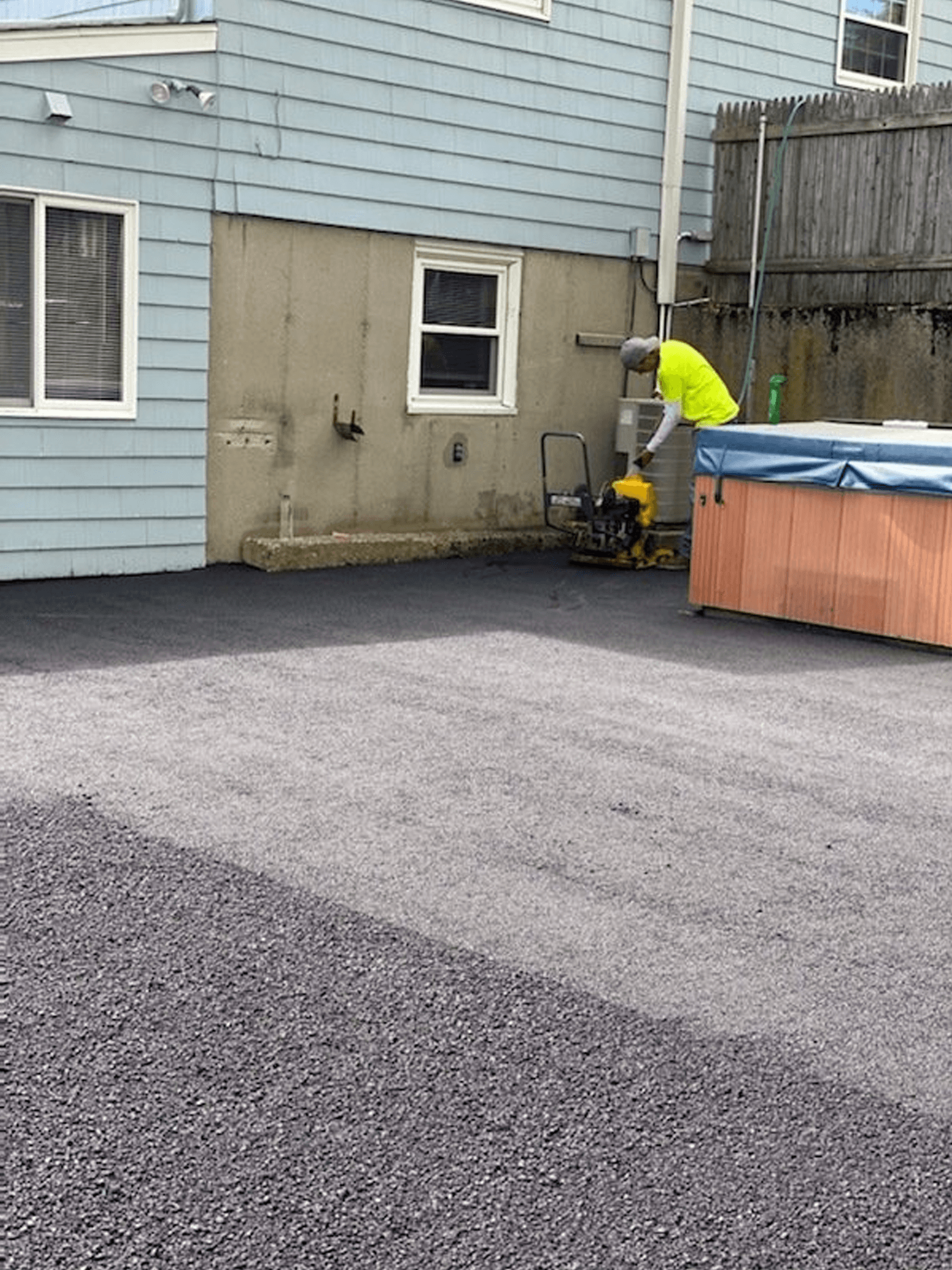 A man is sitting on a ladder in front of a house.