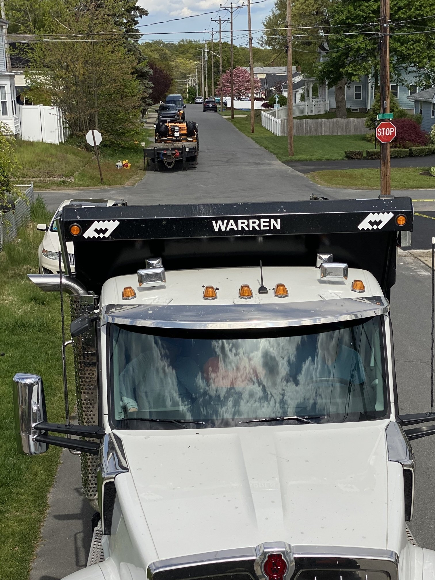 A warren dump truck is driving down a street
