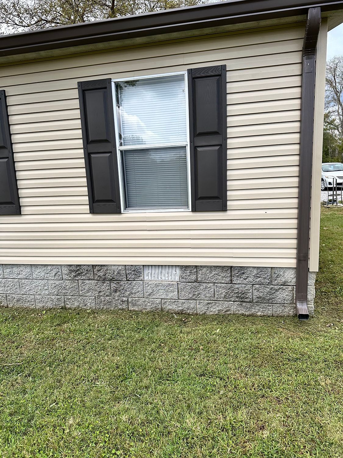 A home with a window, black shutters and gutters.