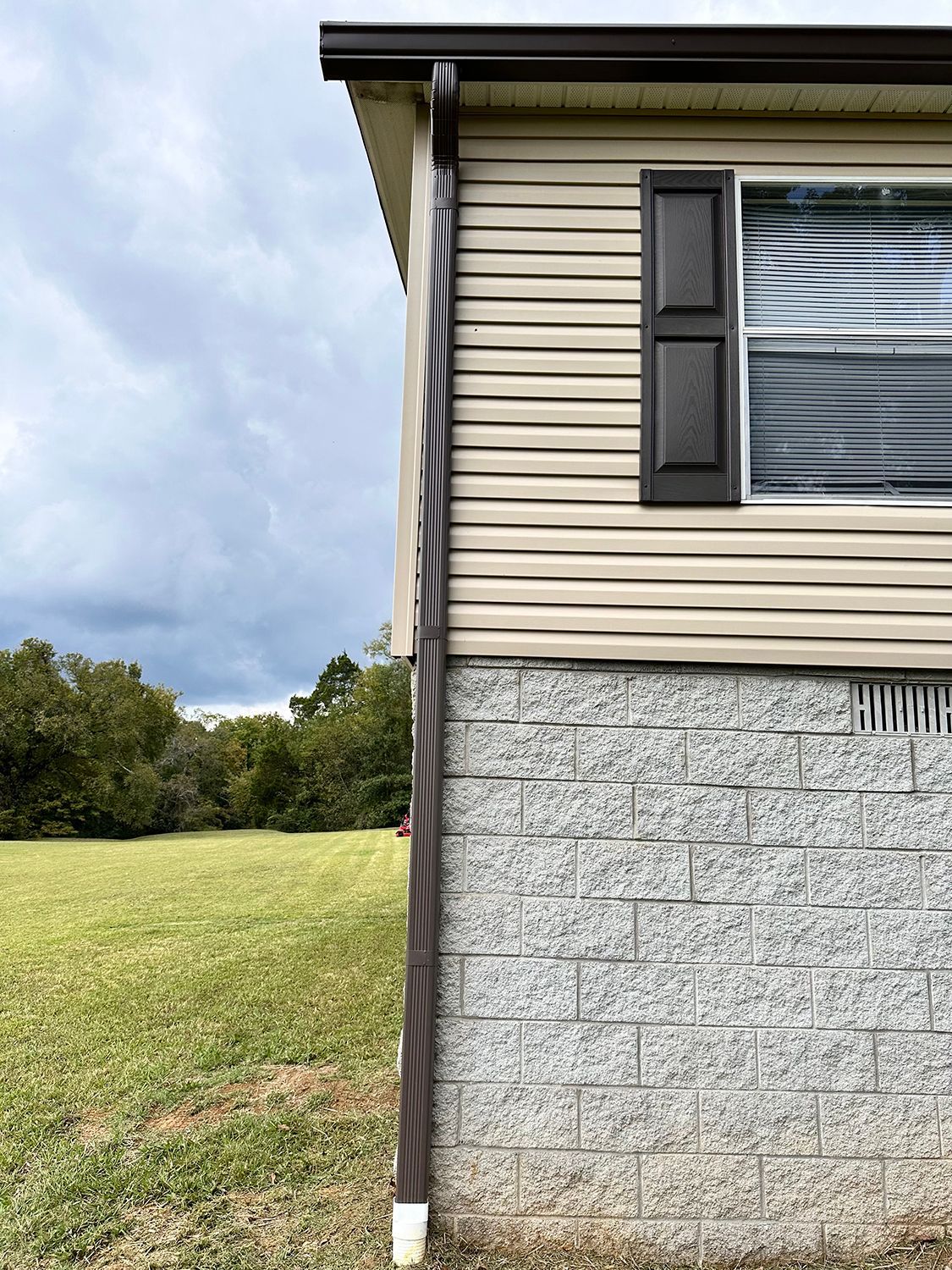 The side of a home with a downspout.