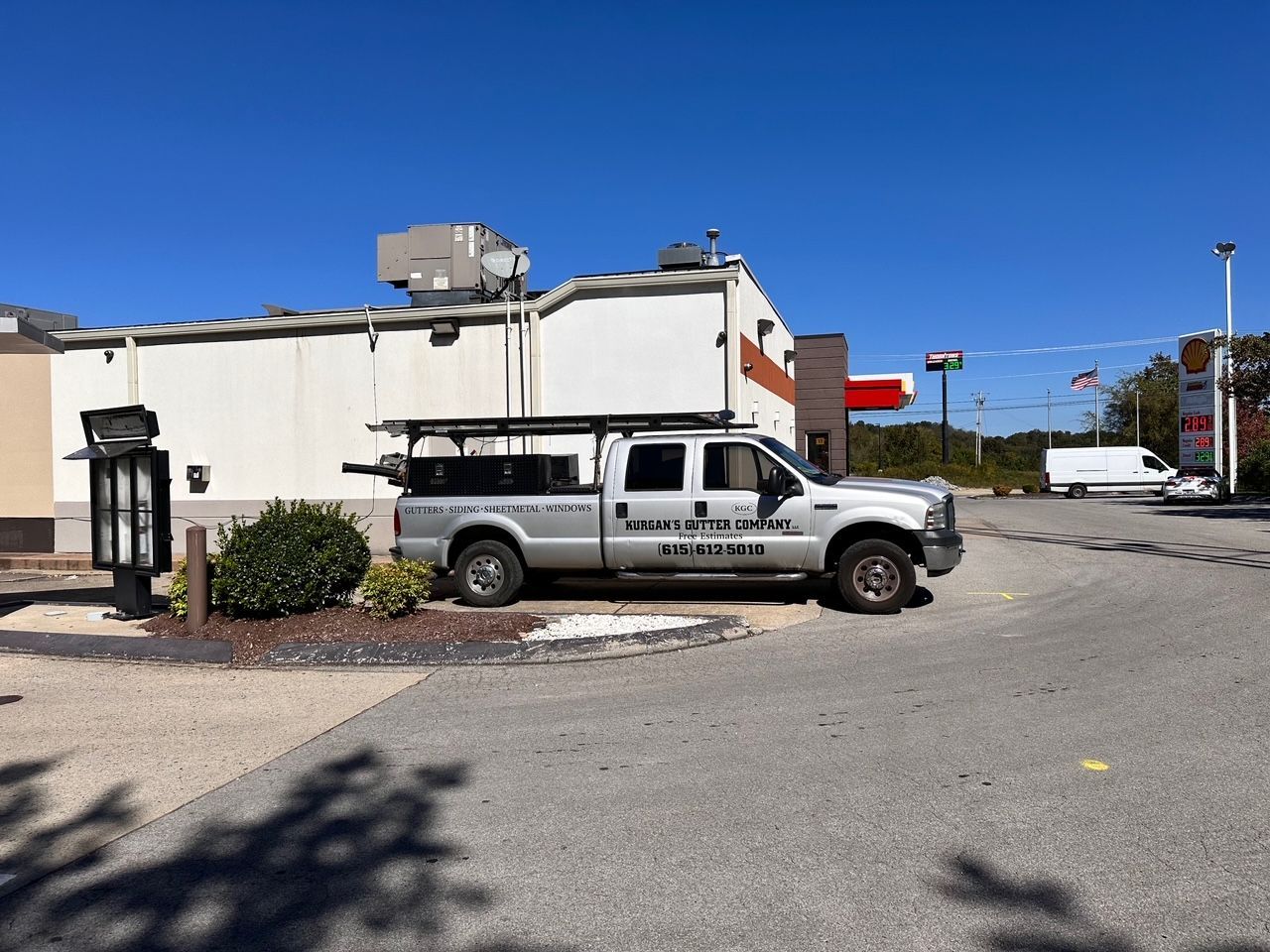 A silver truck is parked in front of a building.