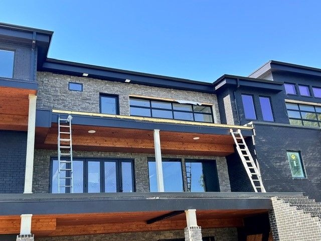 The gutter system of a large house is currently being repaired.