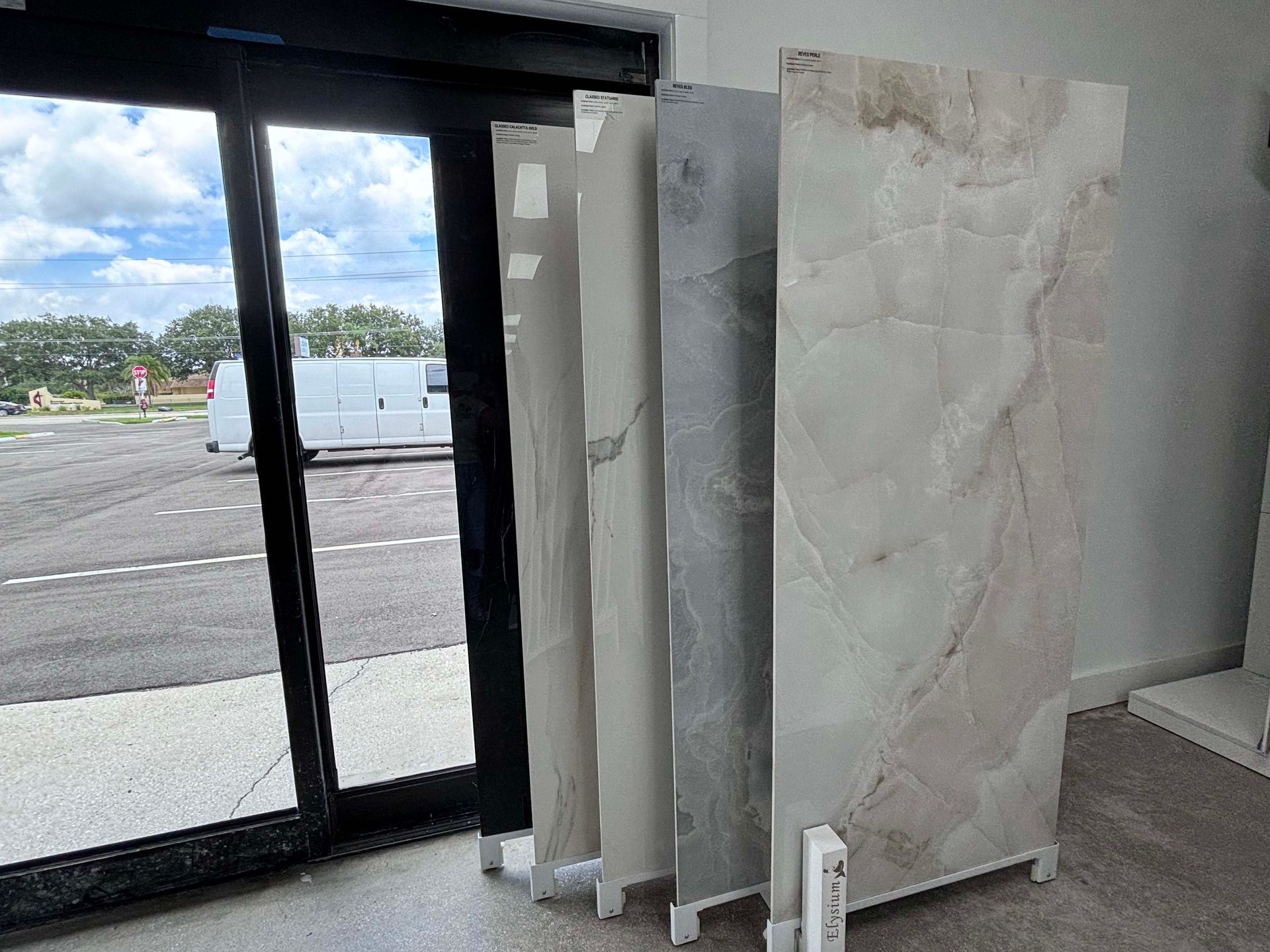 A display of tiles in a store with a van in the background.