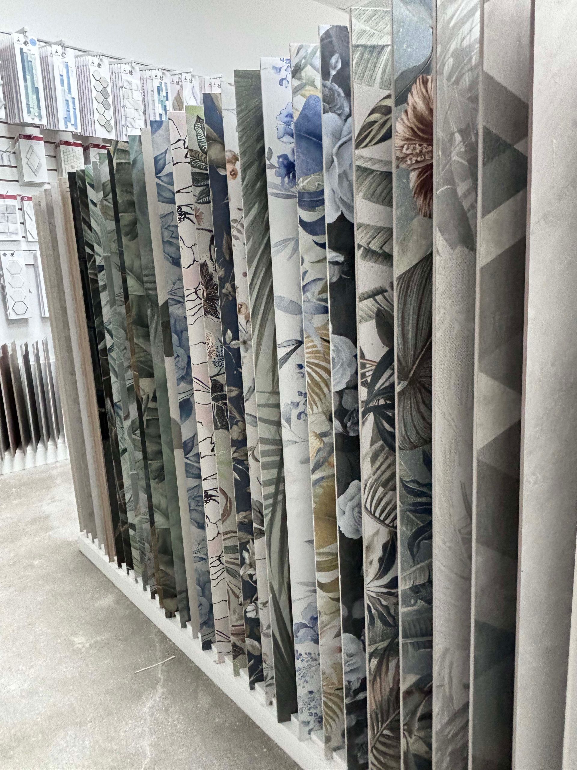A row of rolls of fabric are lined up on a shelf in a store.