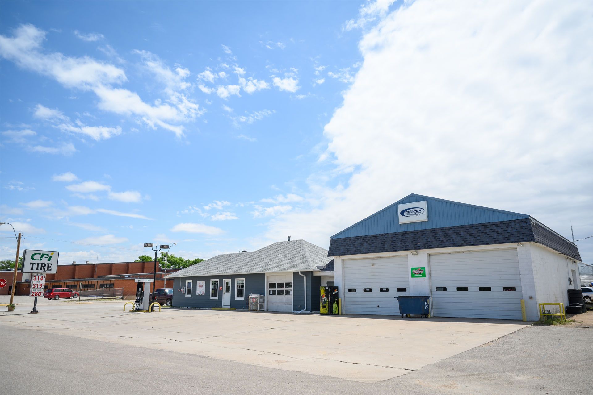 Small auto repair shop with blue-and-white exterior under a bright sky