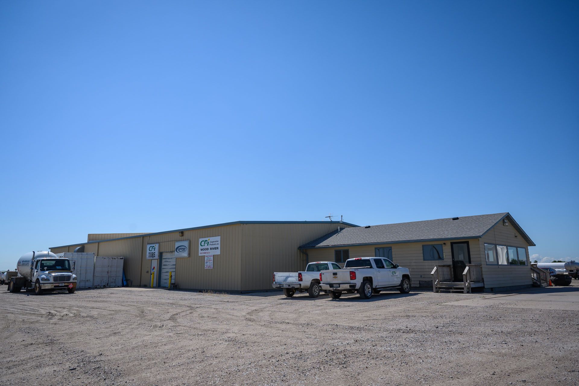 Remote desert building with parked pickup trucks under a clear blue sky