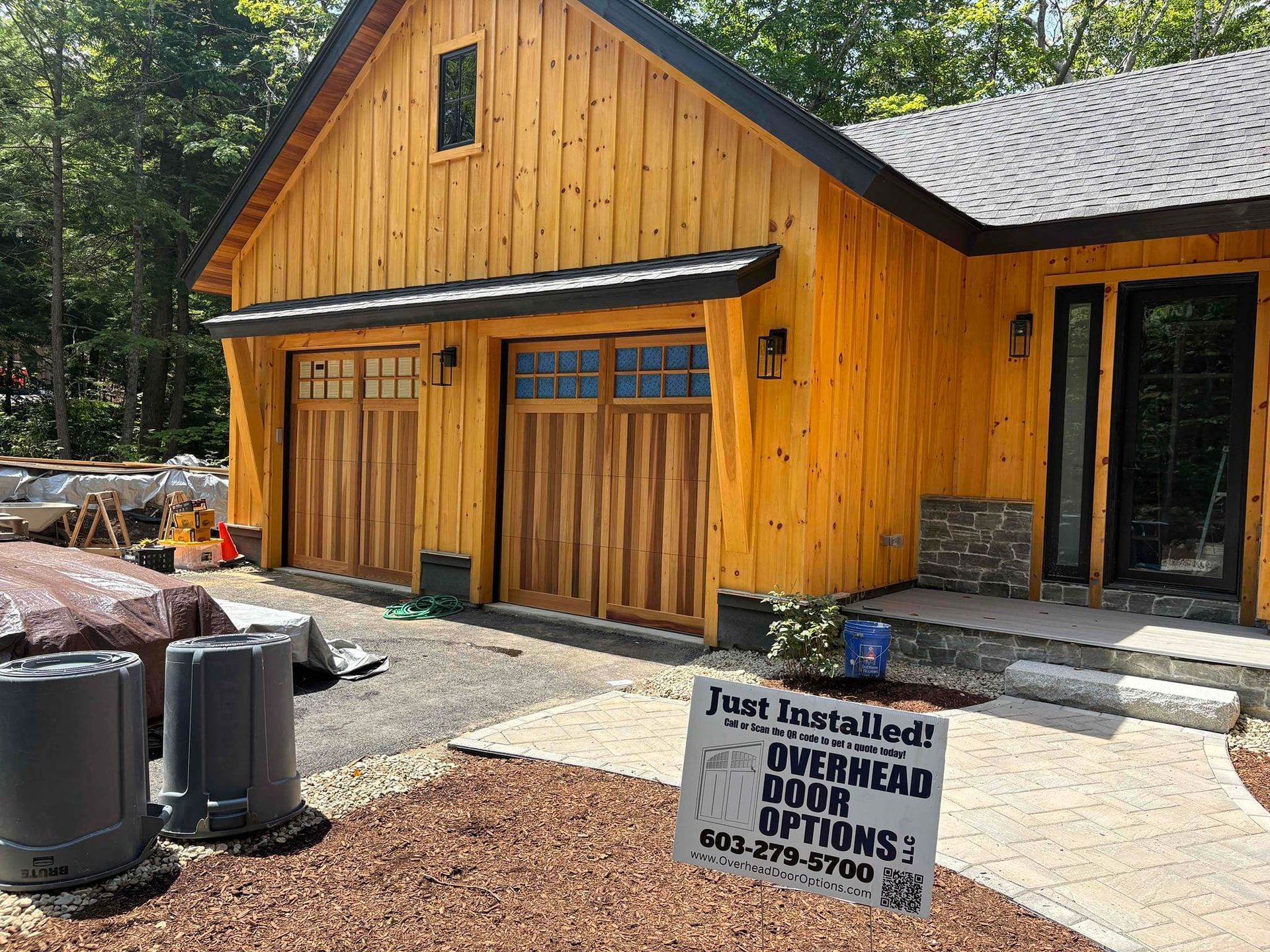 Yellow wooden garage under construction with gravel driveway and a “For Lease” sign in front