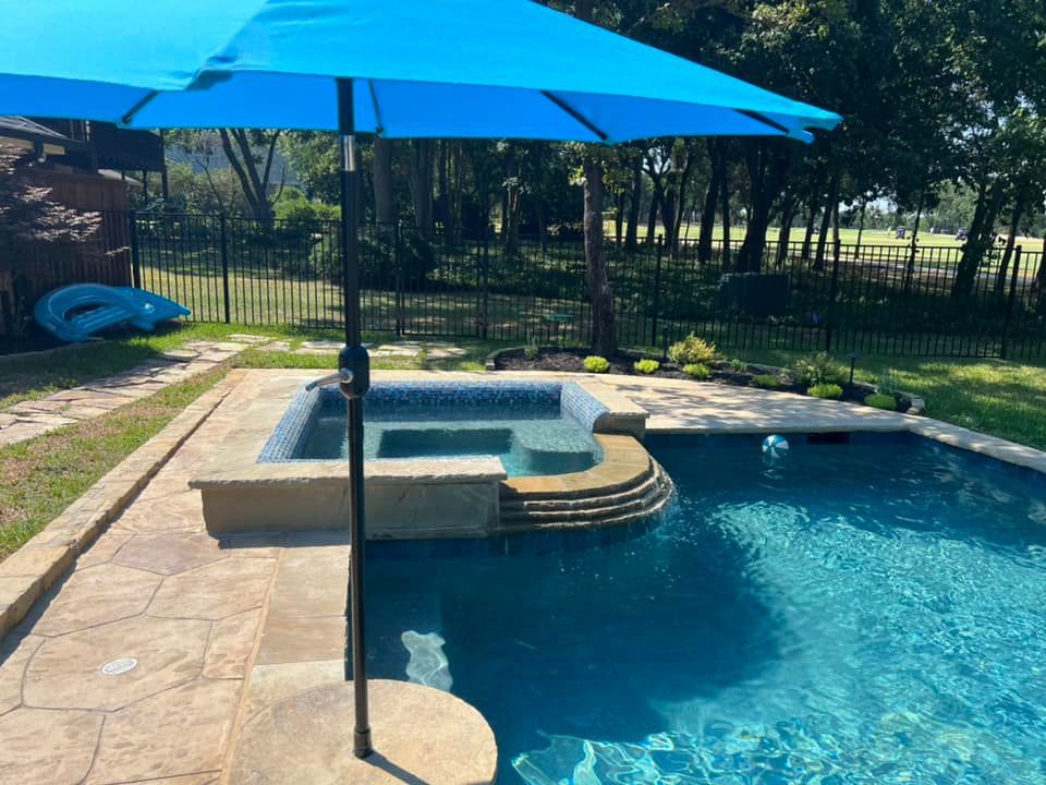 A blue umbrella is sitting next to a swimming pool.