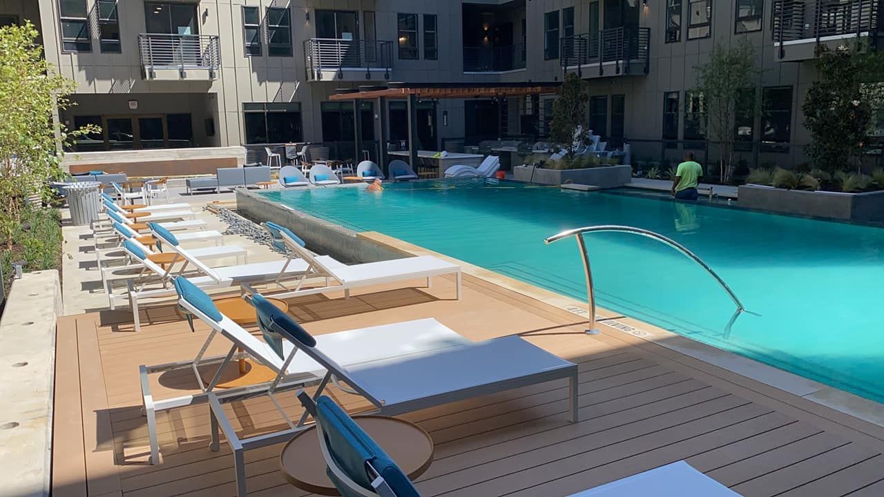 A large swimming pool with a lot of chairs around it