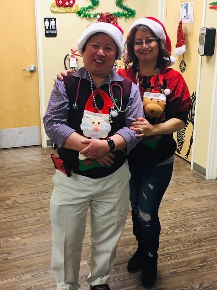 Two people wearing santa hats and sweaters are posing for a picture