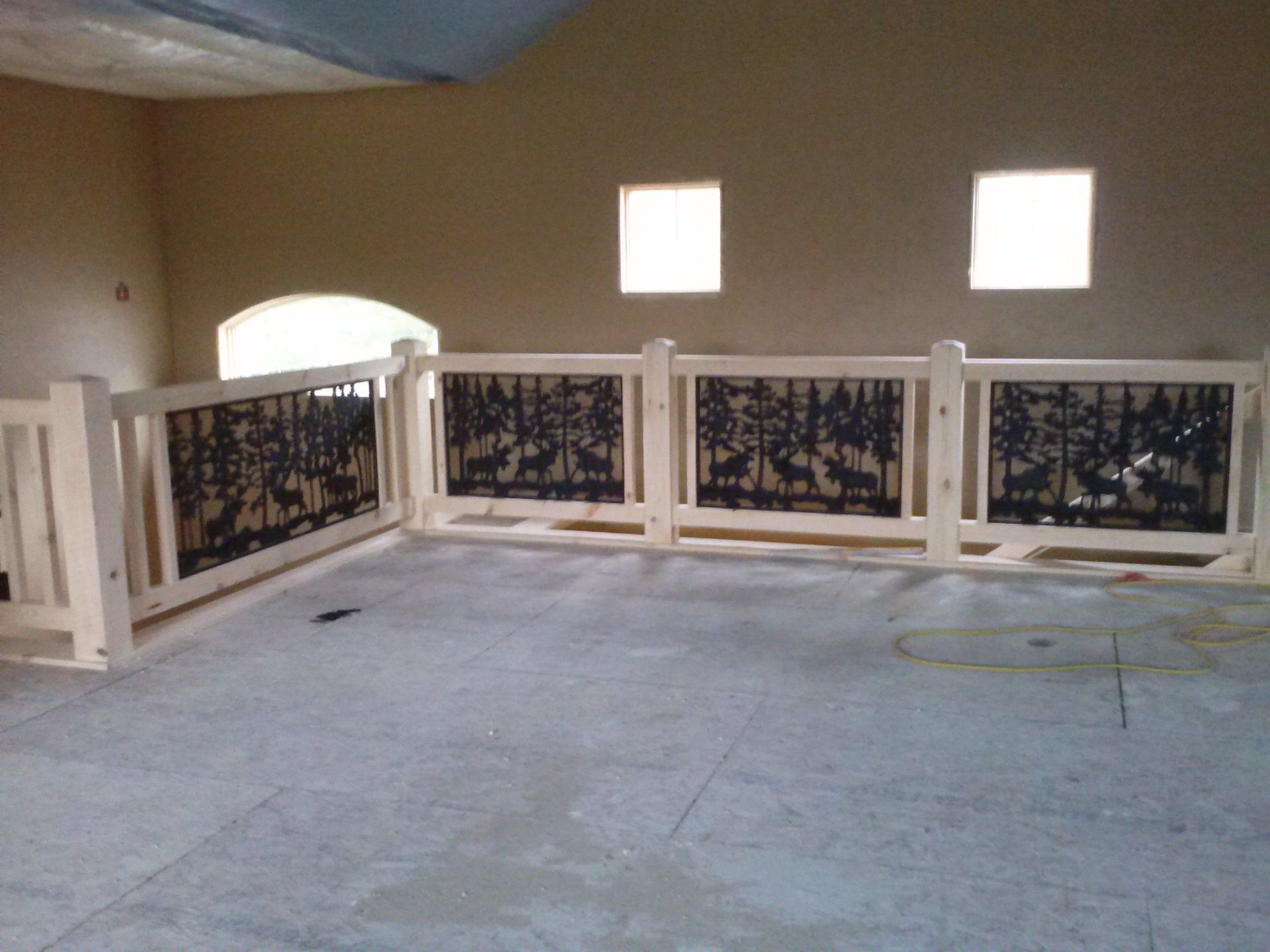 Indoor balcony with white railings and dark decorative panels in a beige room