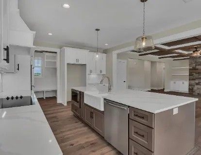 Modern kitchen with white cabinets, island, and stainless steel appliances.