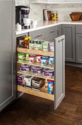 Gray kitchen cabinet with pull-out shelves holding food items, next to a coffee maker.