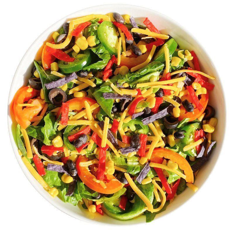 A white bowl filled with a salad of vegetables and cheese