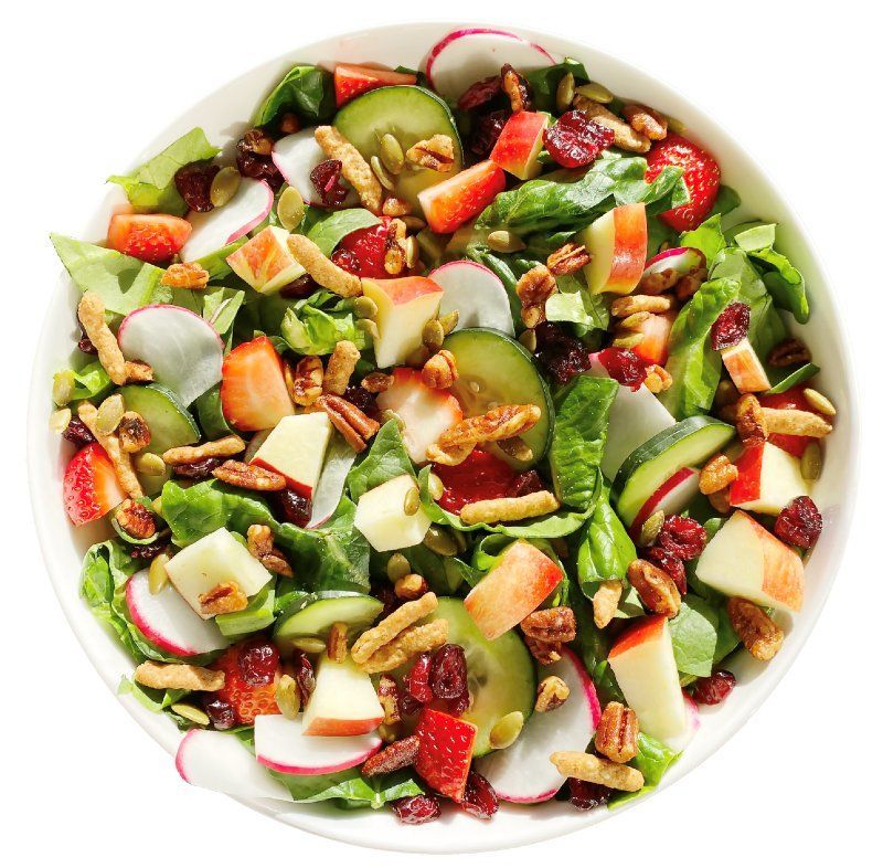A salad with apples , strawberries , cranberries , pecans and spinach in a bowl.